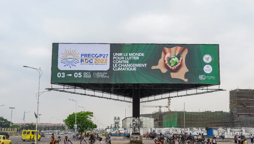 enfants-jouent-Kinshasa-23-septembre-2022-devant-affiche-annoncant-tenue-COP27-1